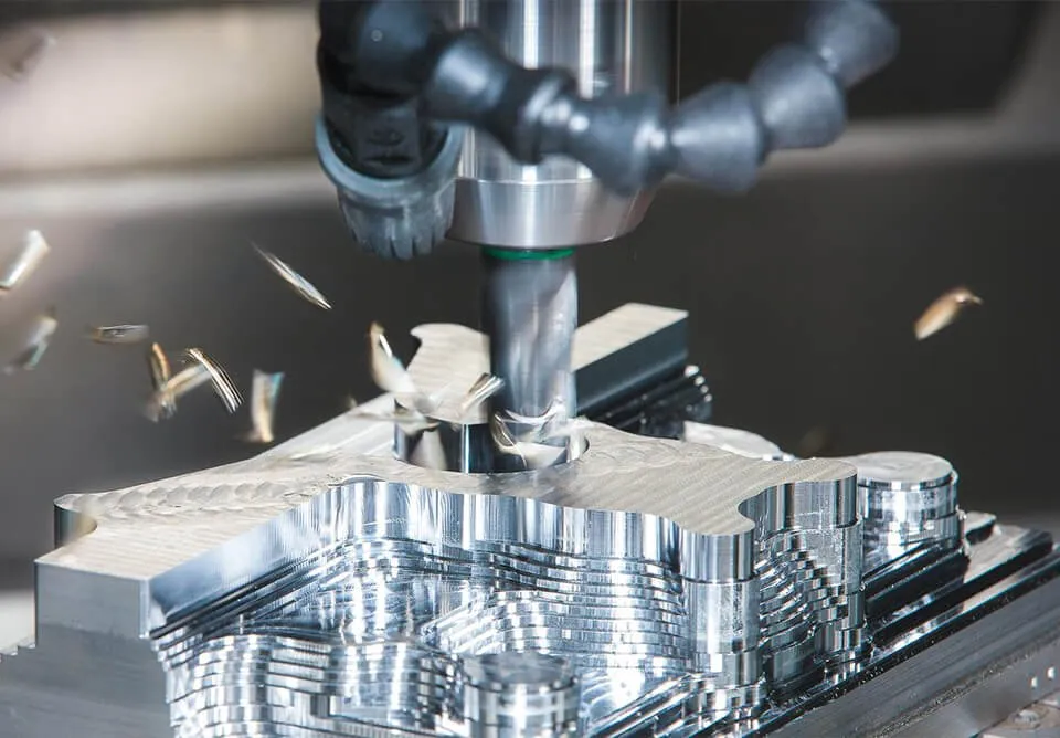 Vertical machining centre milling an aluminium component with coolant